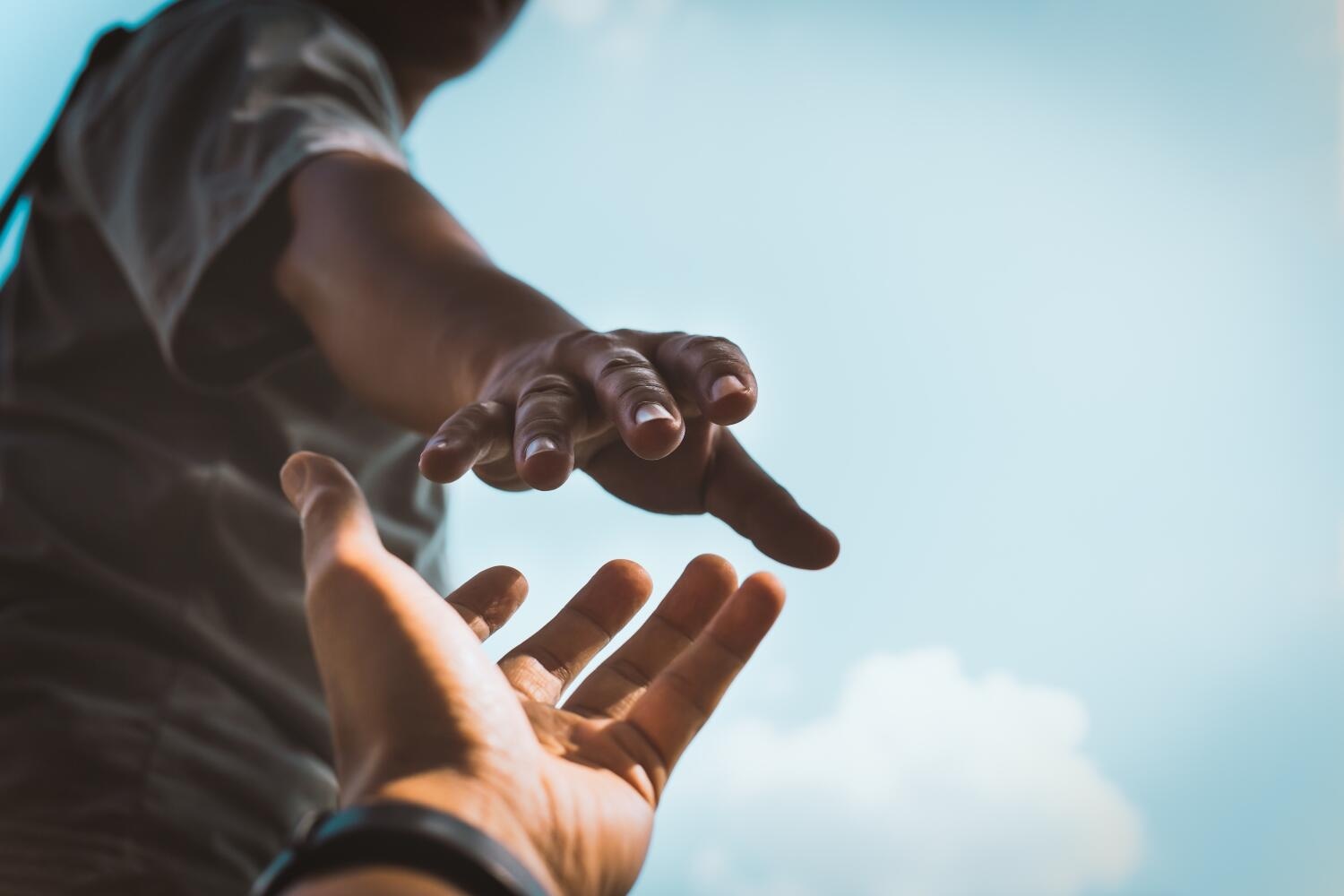 Helping hands. Image of a man holding out his hand to another person - Maui Recovery