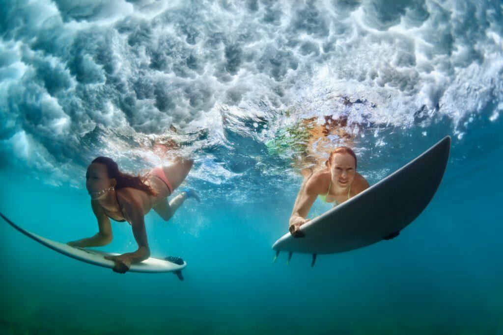 Surfer women with surf board dive underwater under breaking big wave - Maui Recovery