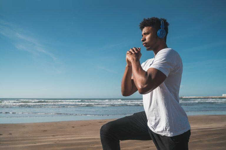 Athletic man doing exercise at the beach - Maui Recovery