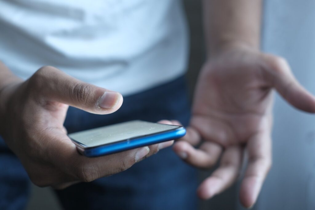 Close up of man's hand using smart phone at night