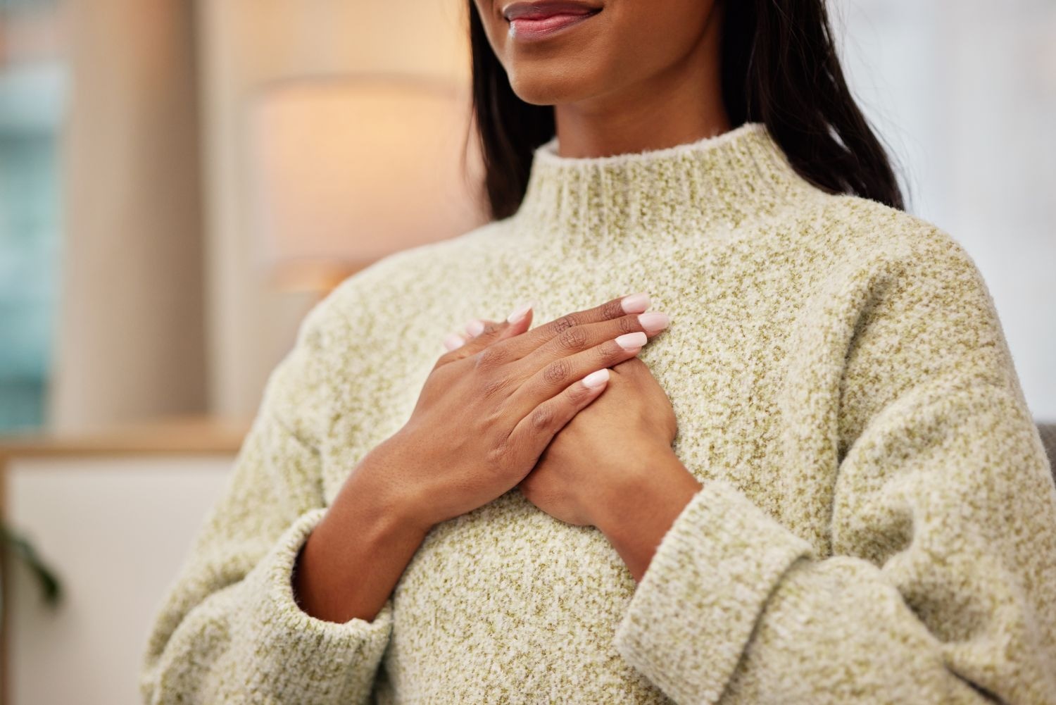 Closeup of a woman holding her chest while breathing for calm, peace and zen mindset for meditation