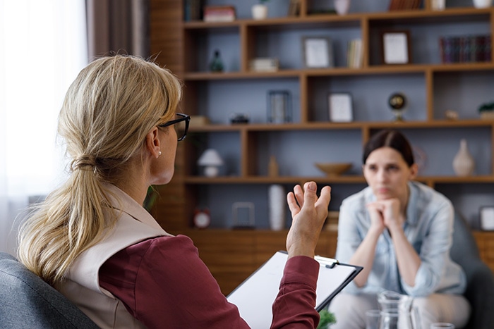 As part of an inpatient treatment program, a woman talks to her therapist.