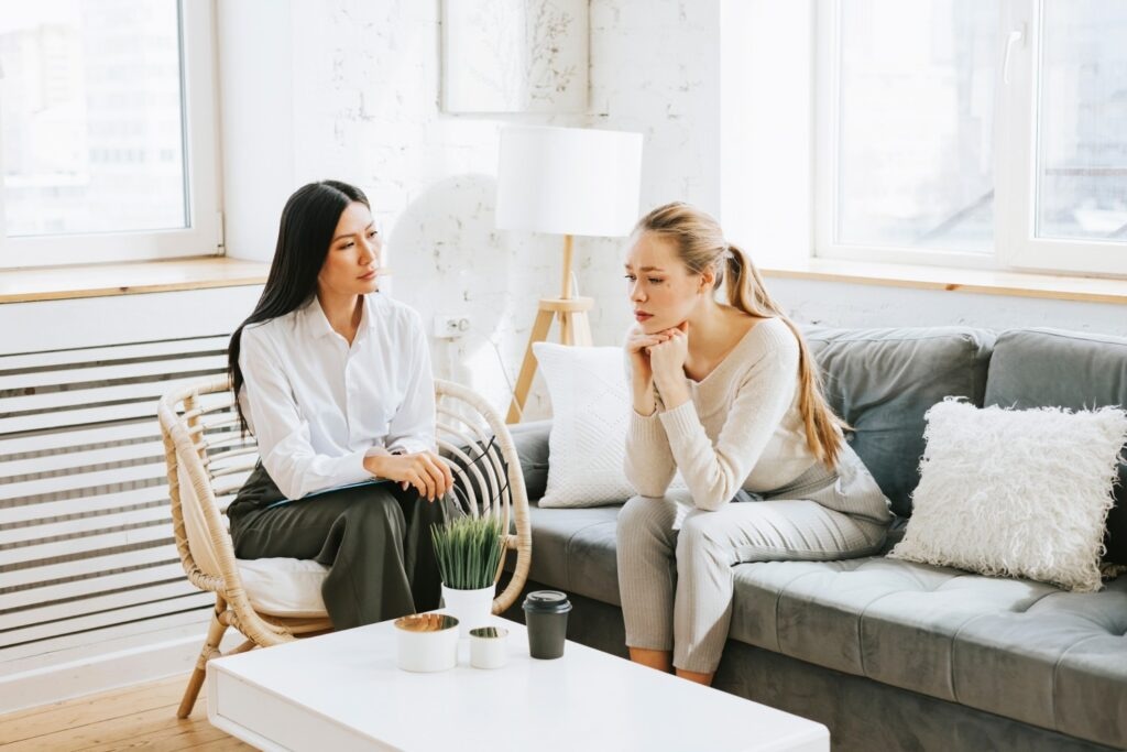 young blonde woman having a deep conversation with a lady therapist