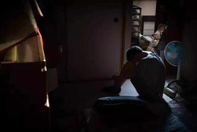 depressed man sitting alone in a dark room