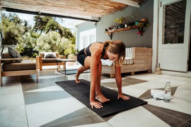 Caucasian female stretching lunging outside house exercising focused while practicing yoga . High quality photo