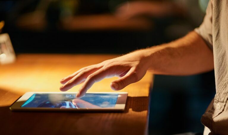 I have all I need at my fingertips. Cropped shot of a man using his digital tablet